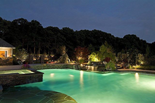 home backyard with the water fountain for swimming pool at night